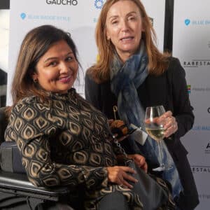 Dark haired woman in wheelchair with white woman in black jacket